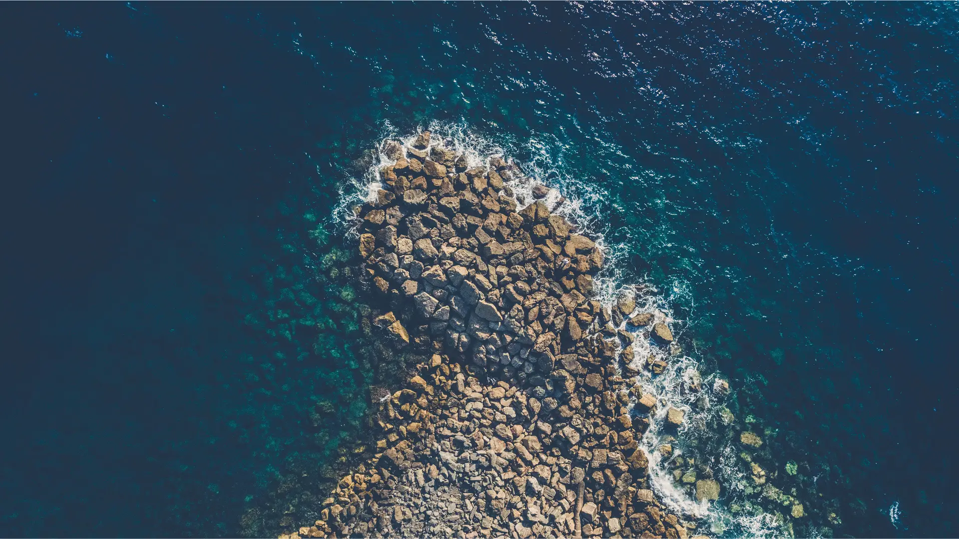 a_rocky_shore_with_waves_crashing_on_it.jpg