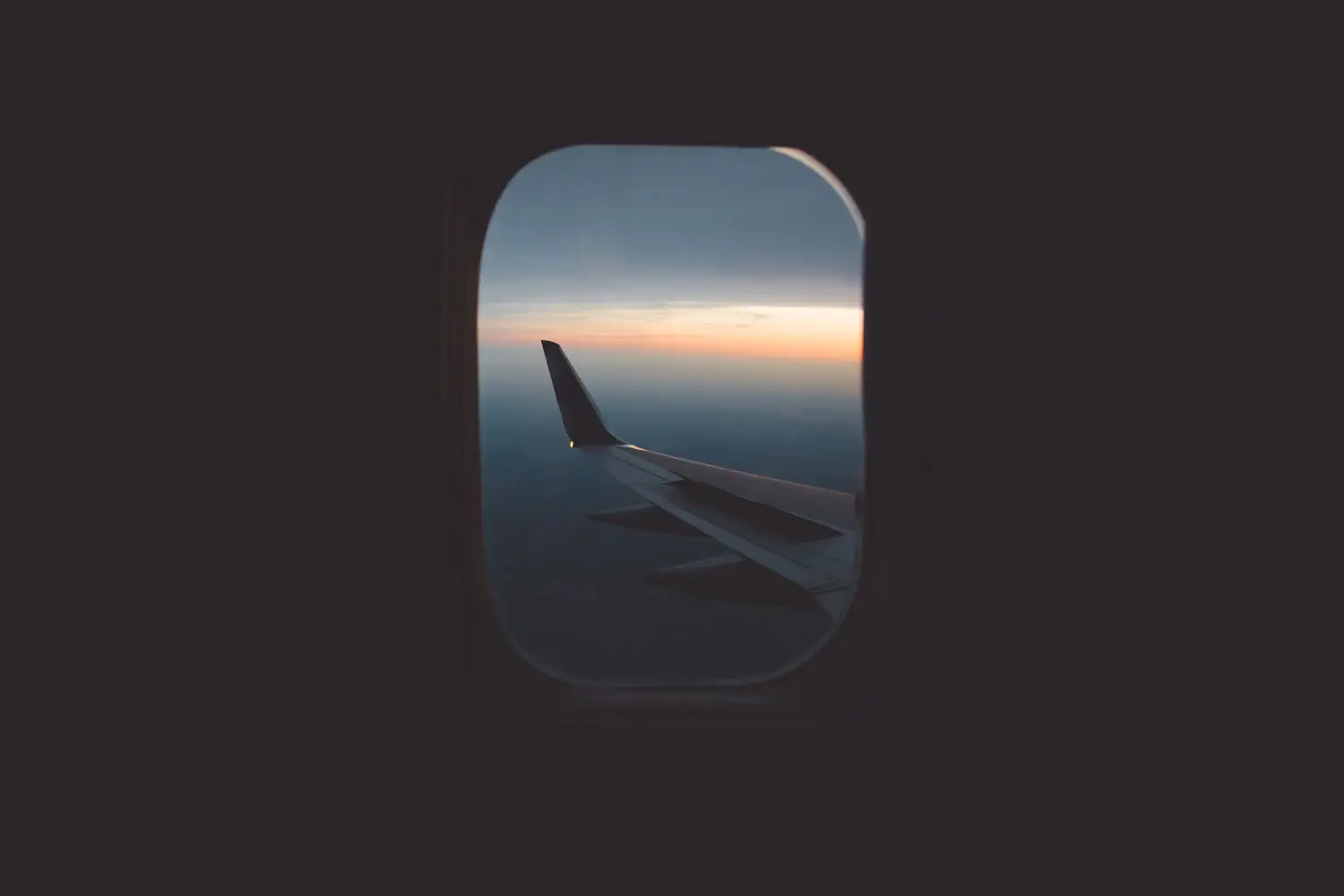 an_airplane_wing_seen_through_a_window.jpg