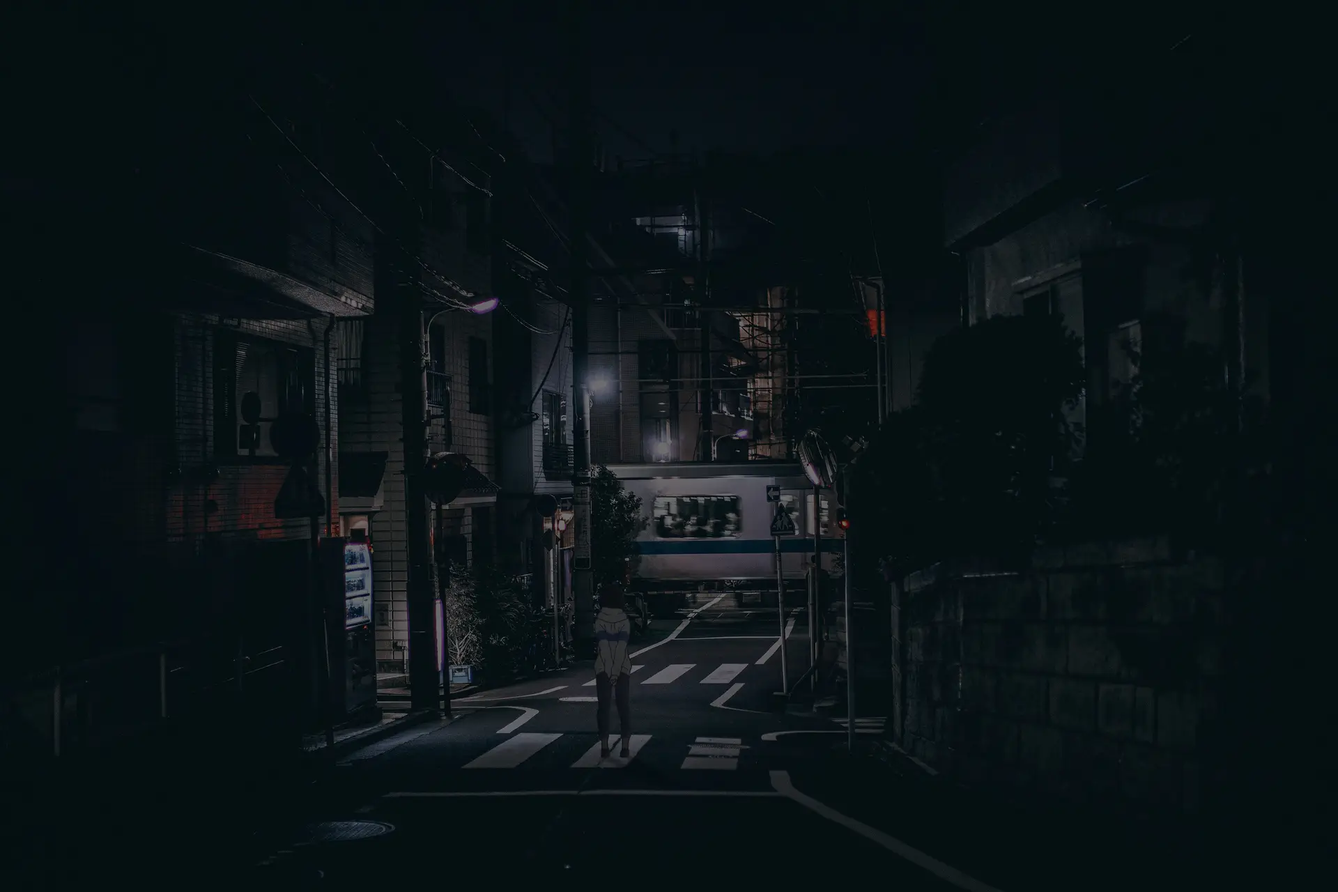 a_person_standing_on_a_street_at_night.png