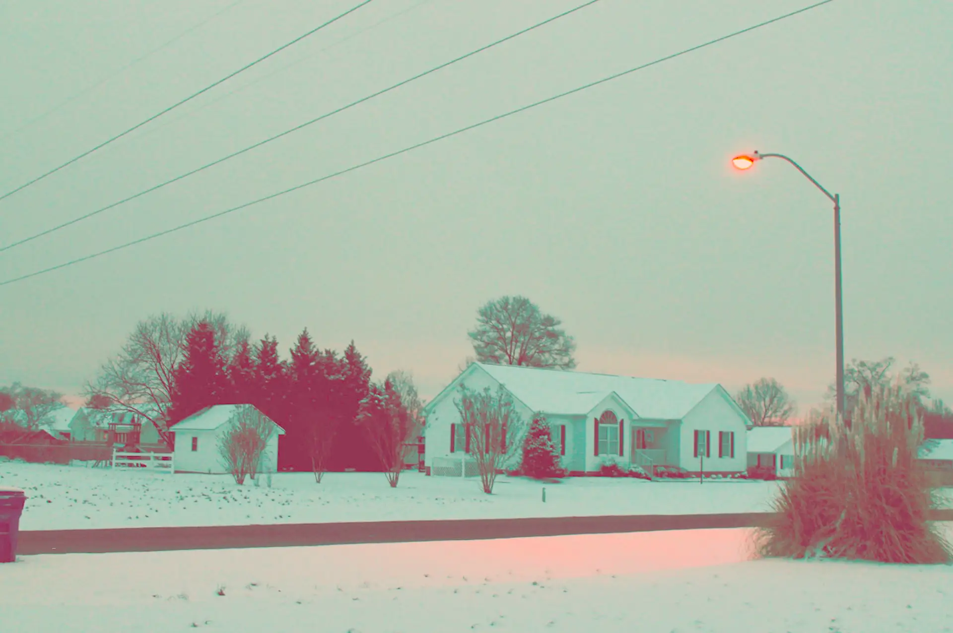 a_snow_covered_houses_and_a_street_light.png