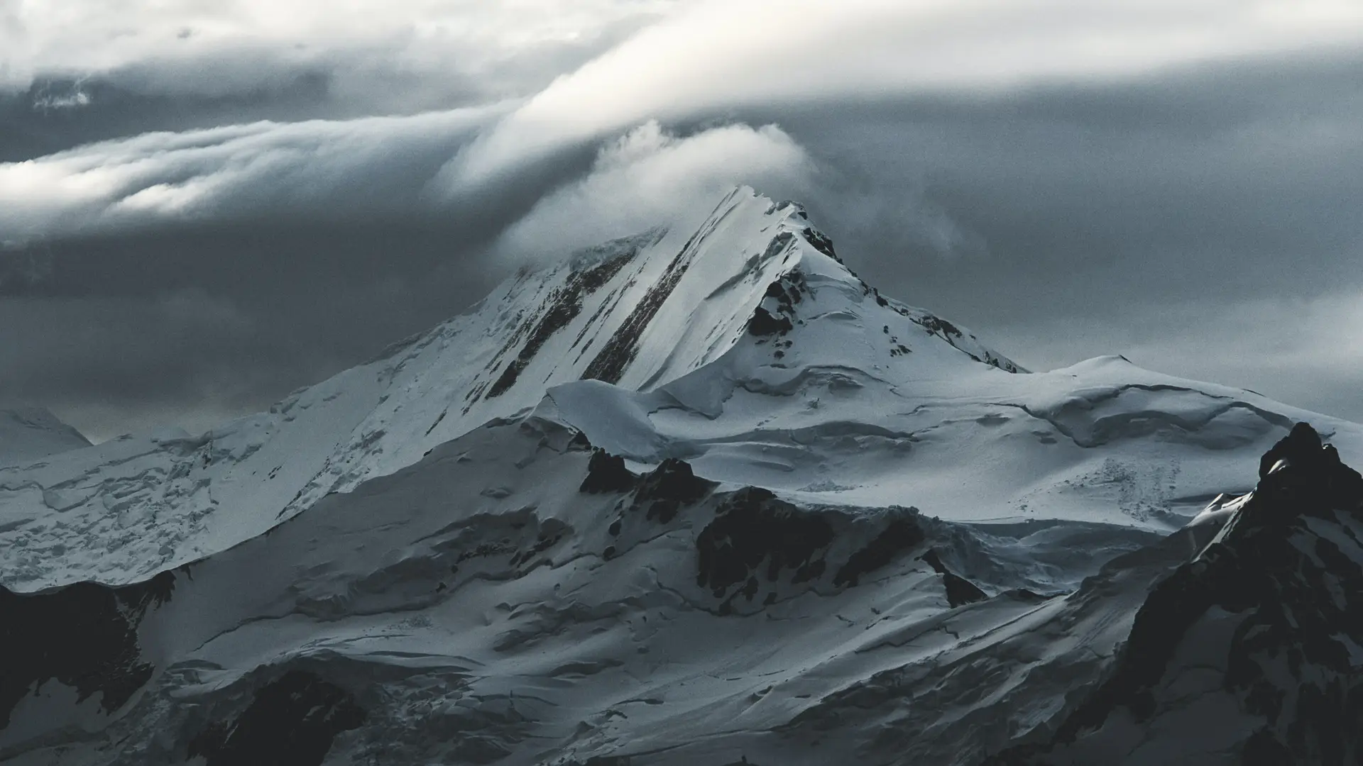 a_snowy_mountain_with_clouds_above.jpg