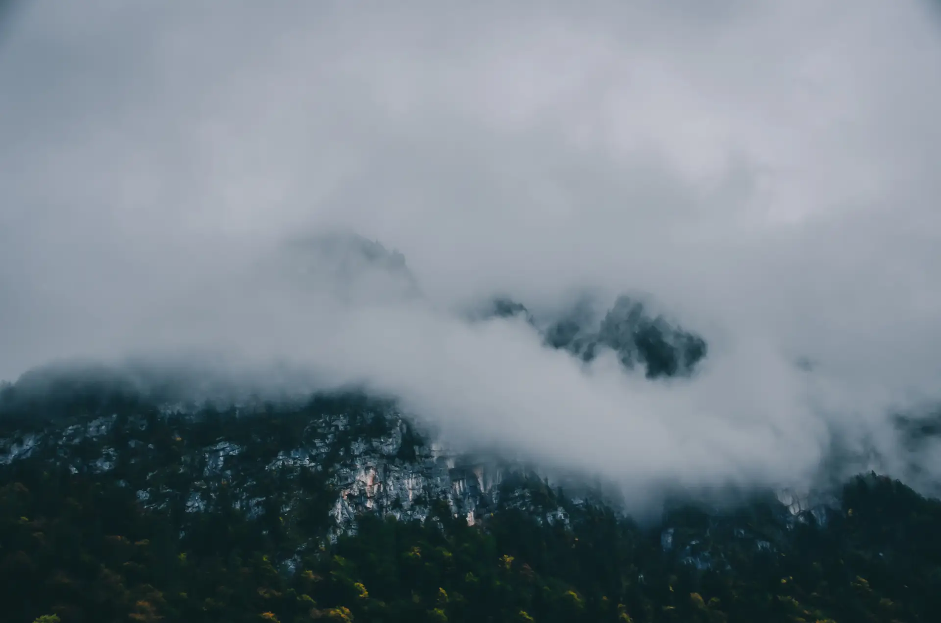 a_mountain_with_clouds_and_trees.jpg