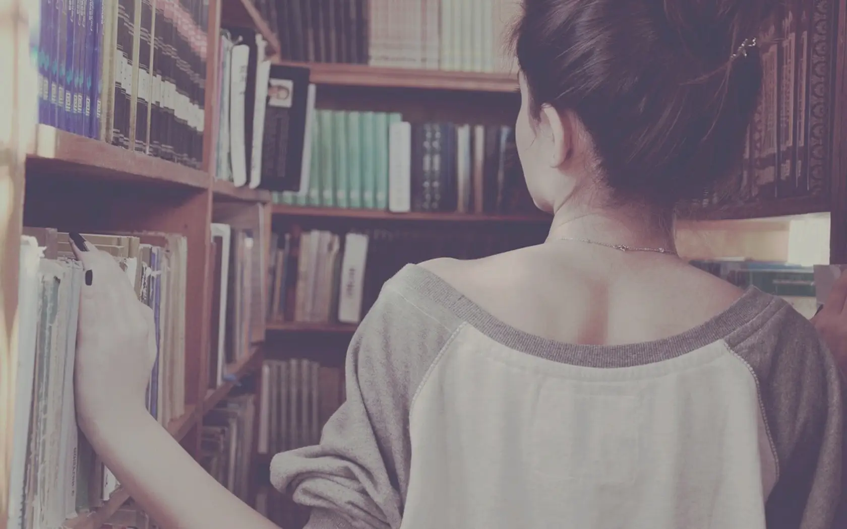 a_woman_standing_in_front_of_a_bookshelf.jpg