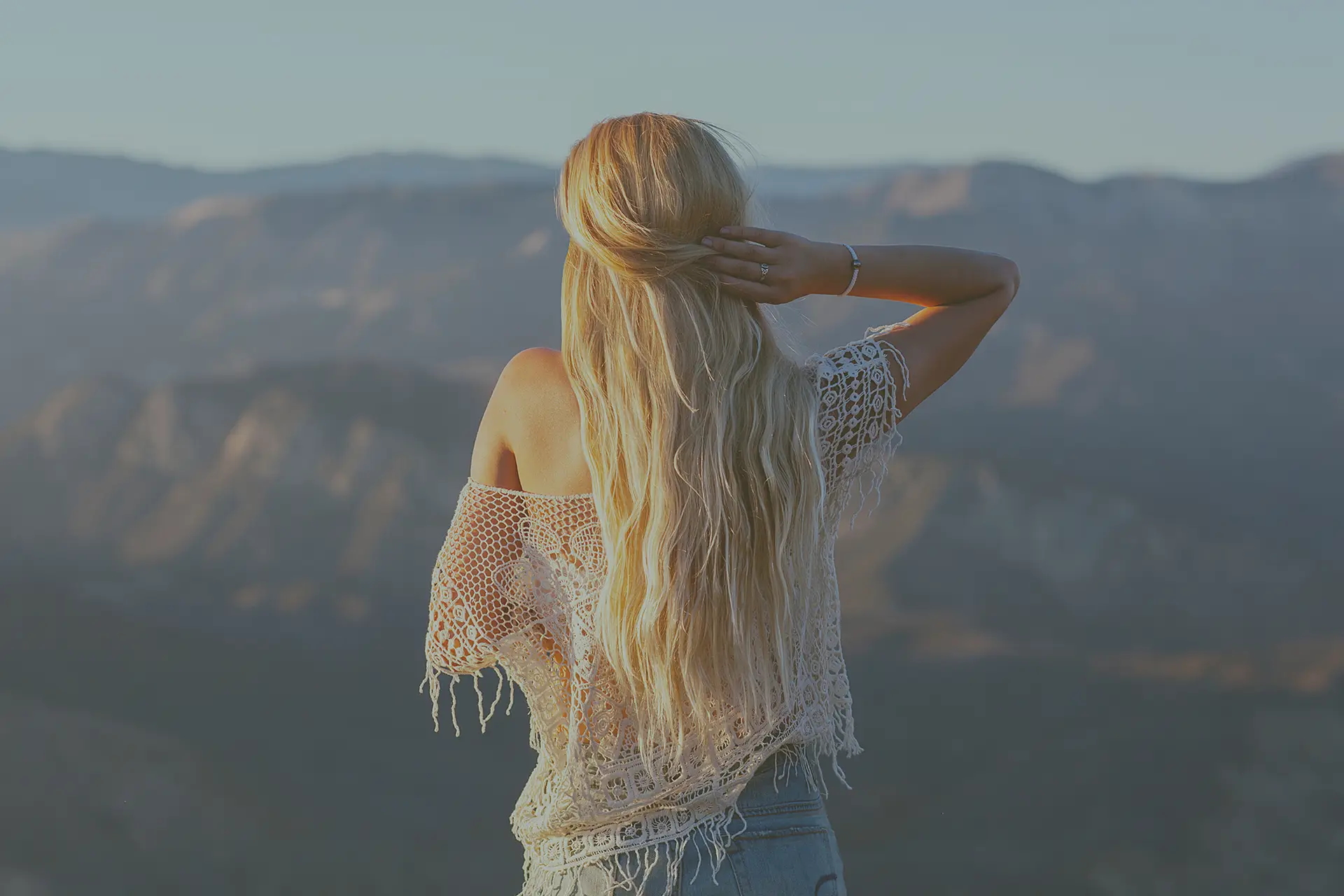 a_woman_standing_on_a_mountain.jpg