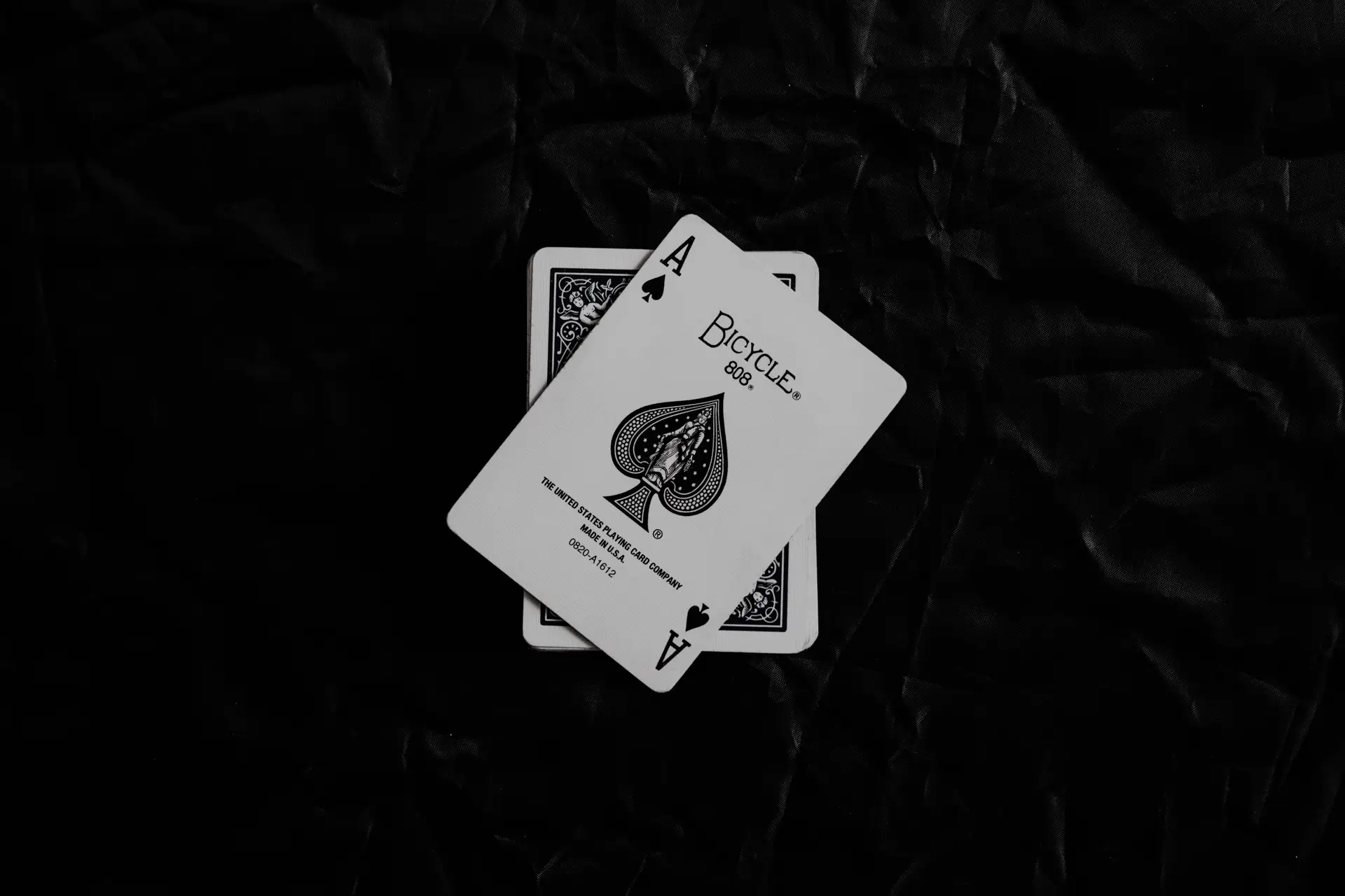 a_pair_of_playing_cards_on_a_black_surface.jpg