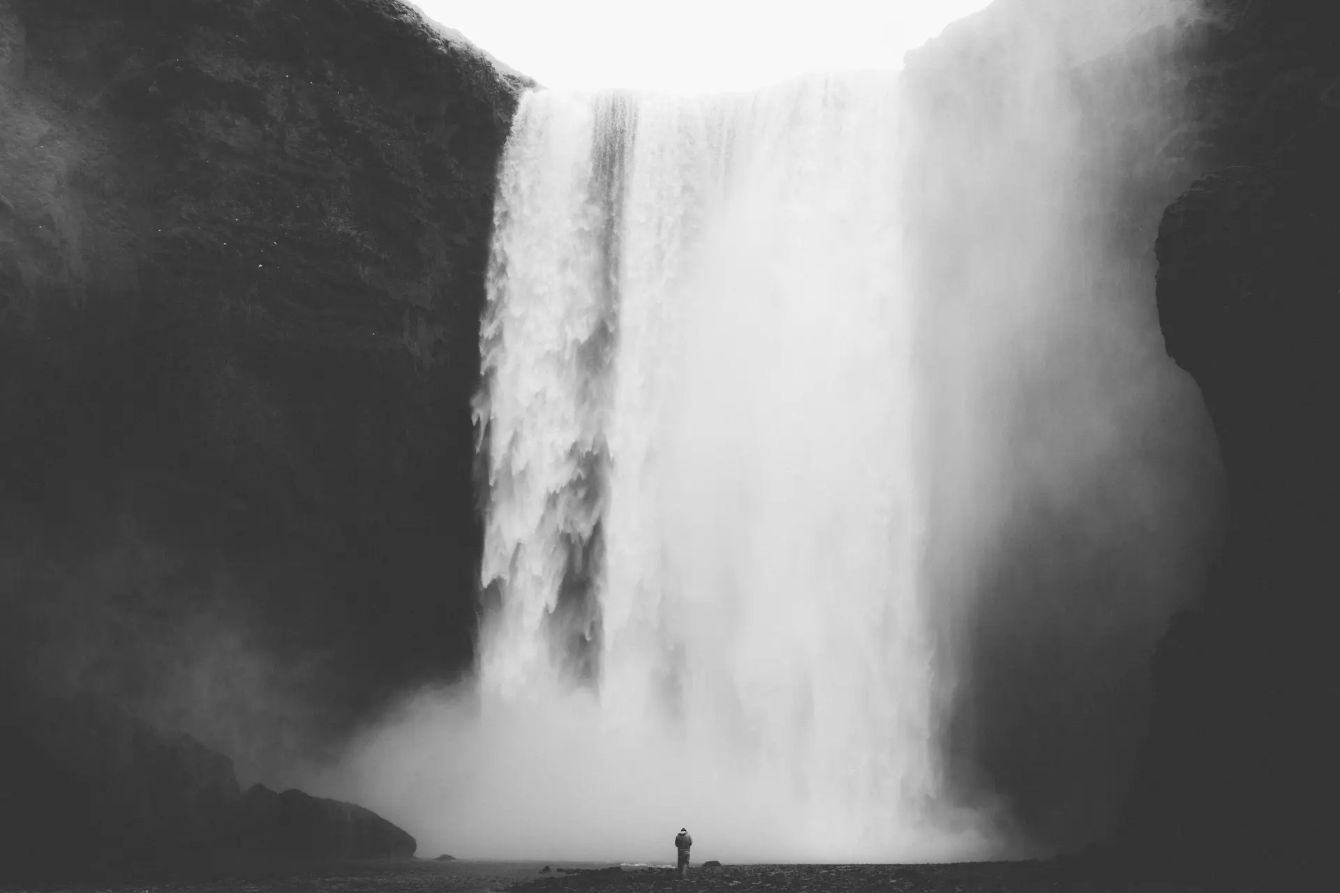 a_person_standing_in_front_of_a_waterfall.jpg