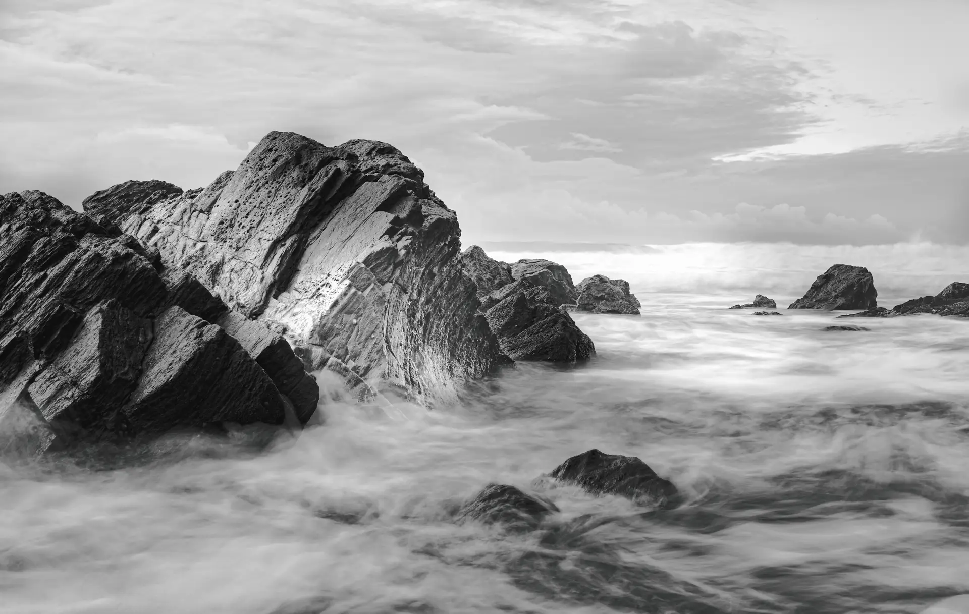 a_rocky_beach_with_waves_crashing_onto_rocks.jpg