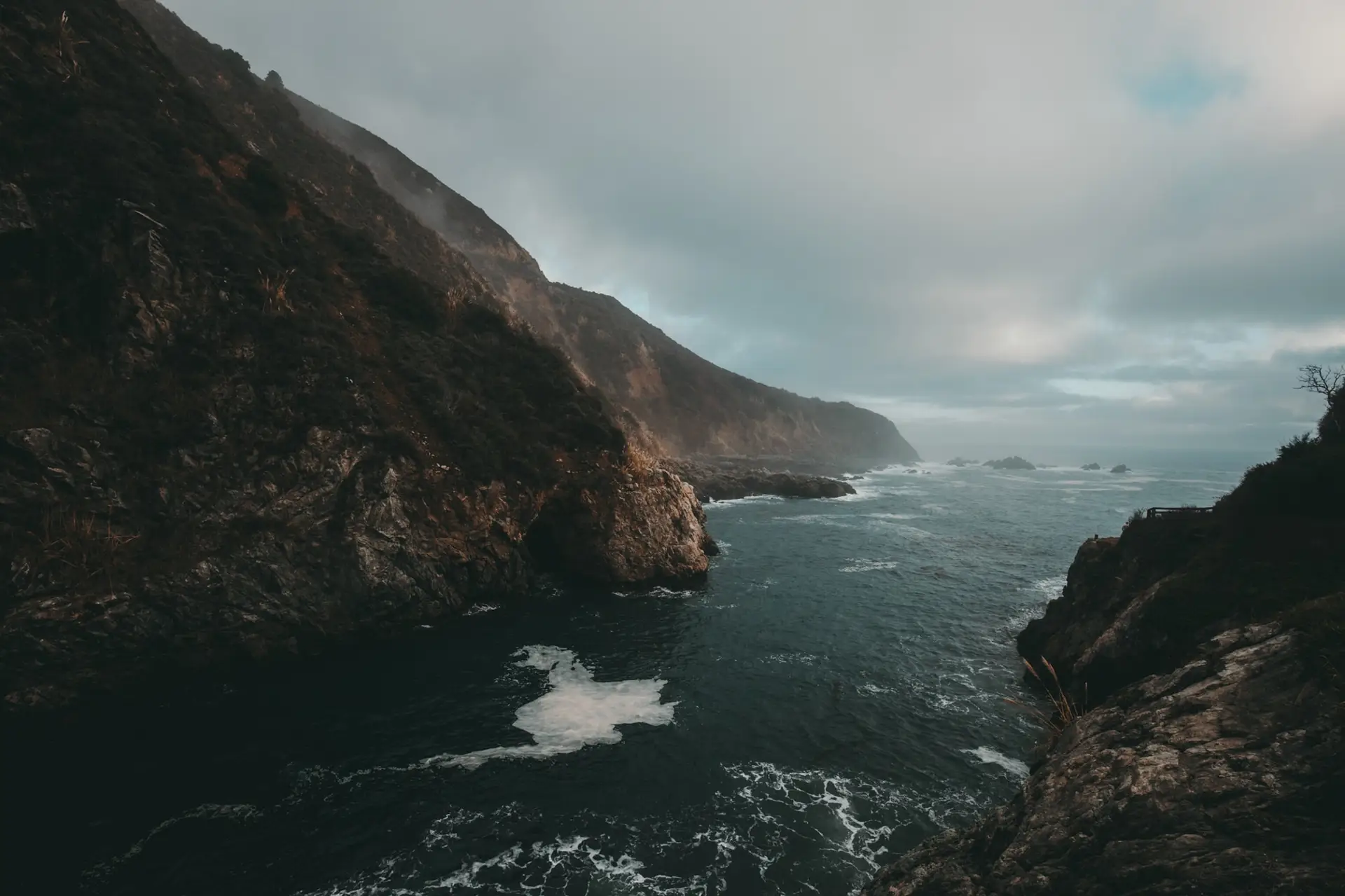 a_body_of_water_with_rocks_and_a_cliff.jpg