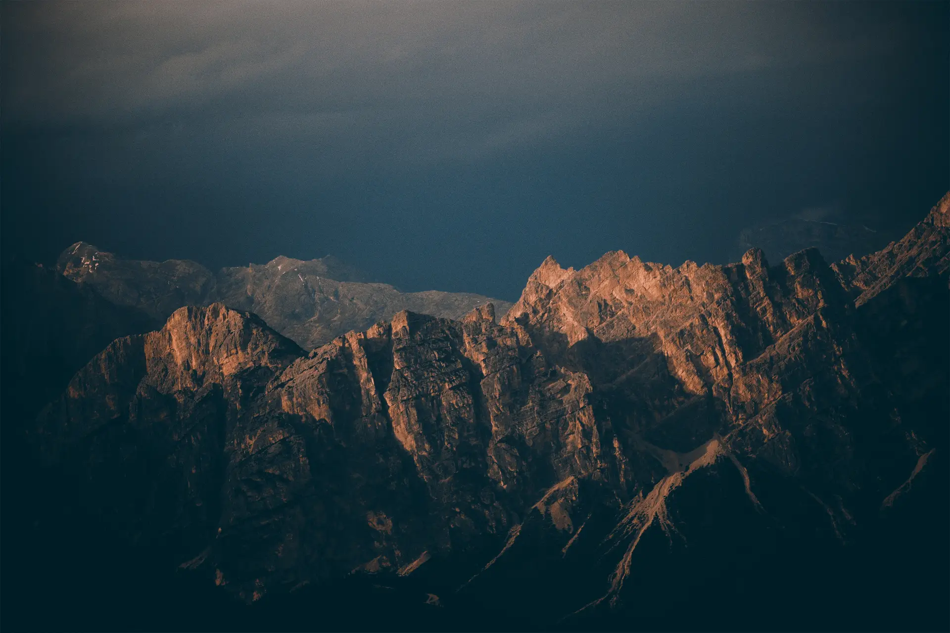 a_mountain_range_with_dark_clouds.jpg