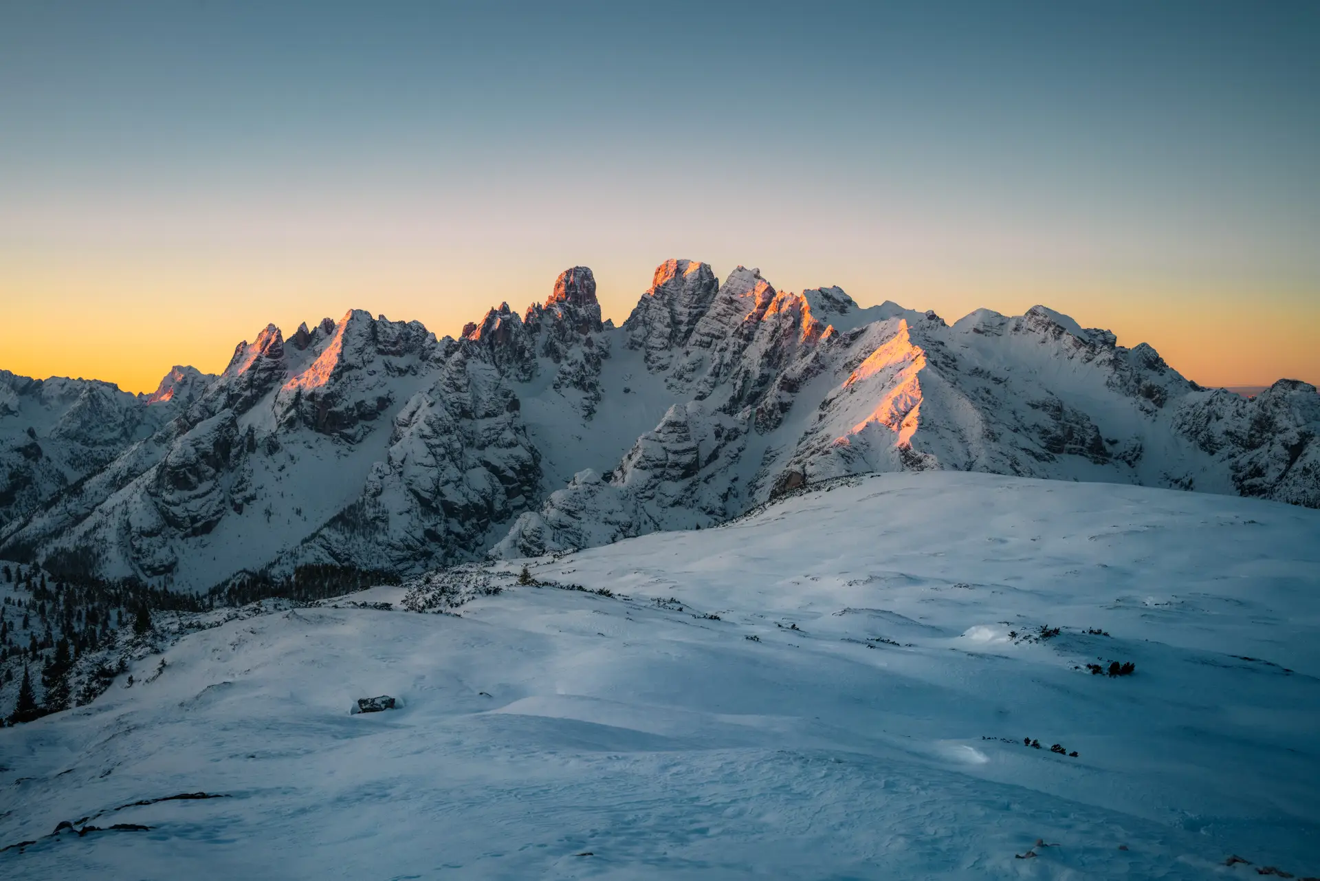 a_snowy_mountain_range_with_sun_shining_on_it.jpg