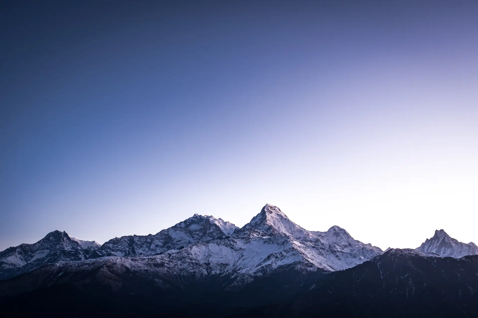 a_snowy_mountain_tops_with_blue_sky.jpg