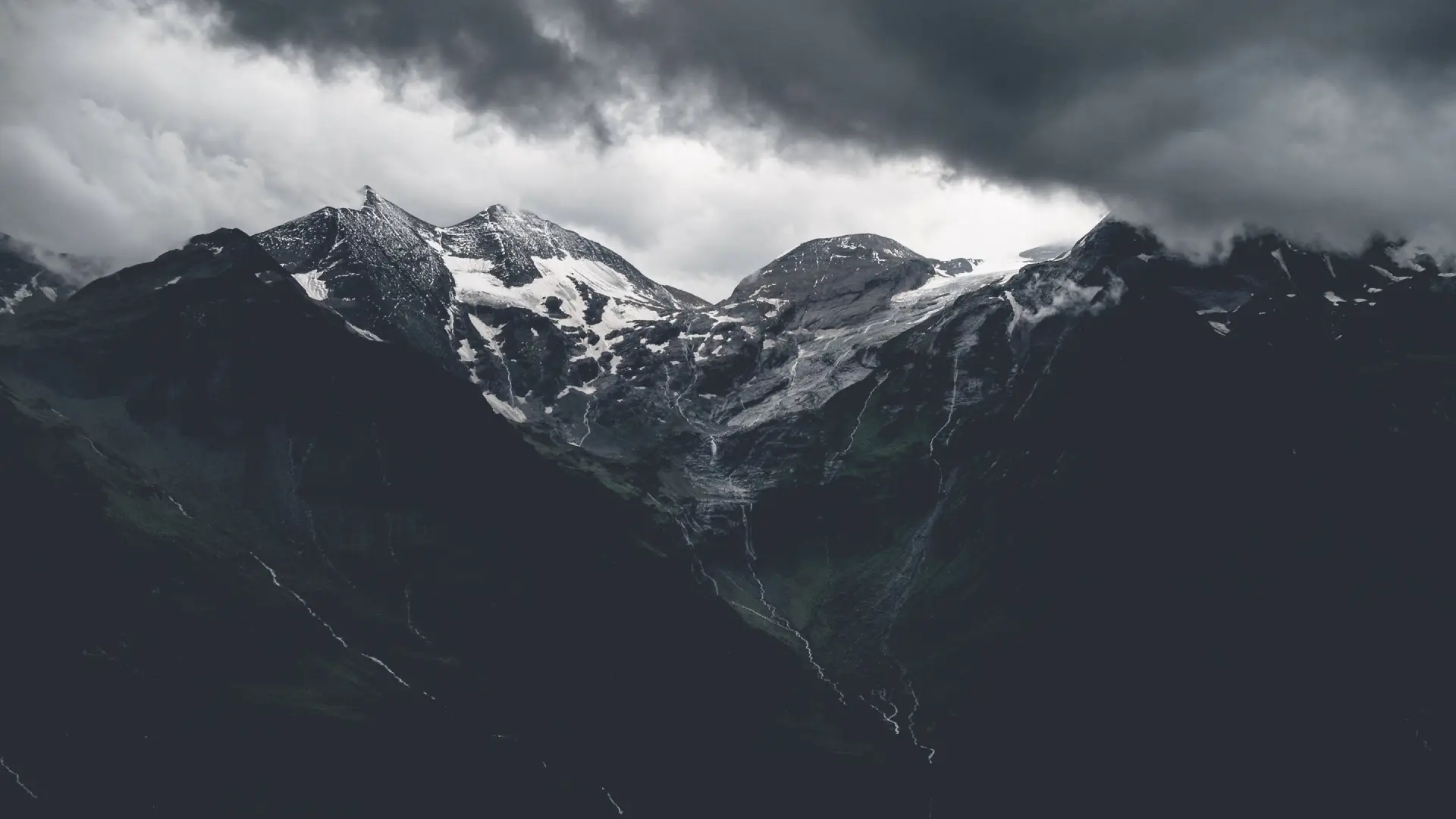 a_snowy_mountain_tops_with_clouds_in_the_background.png