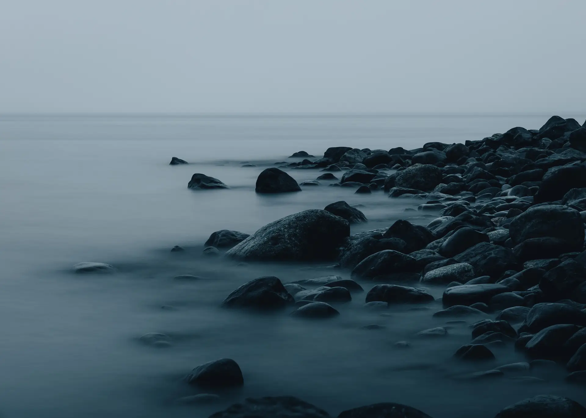 a_rocky_beach_with_water_in_the_background.jpg