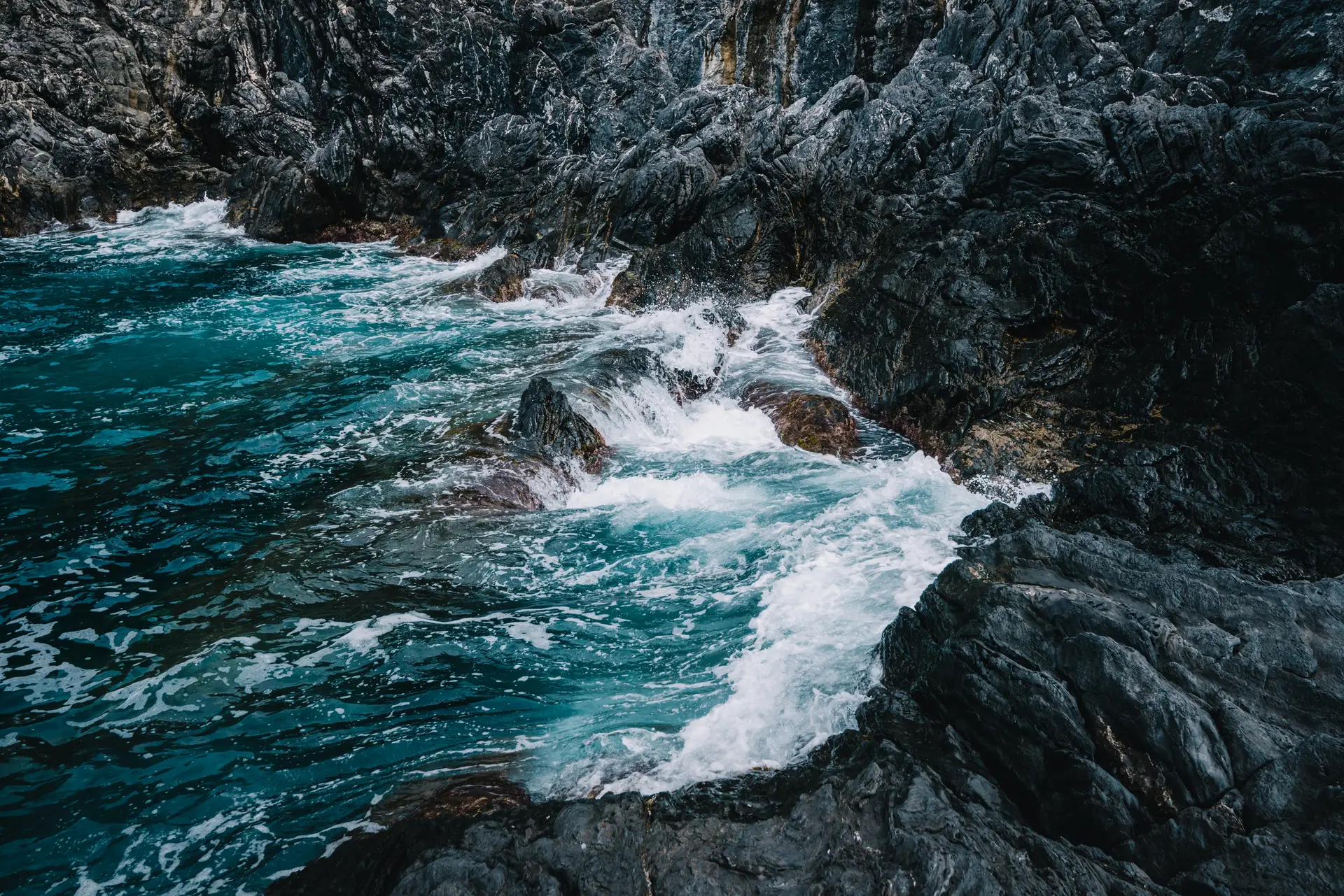 a_rocky_shore_with_waves_crashing_on_rocks.jpg